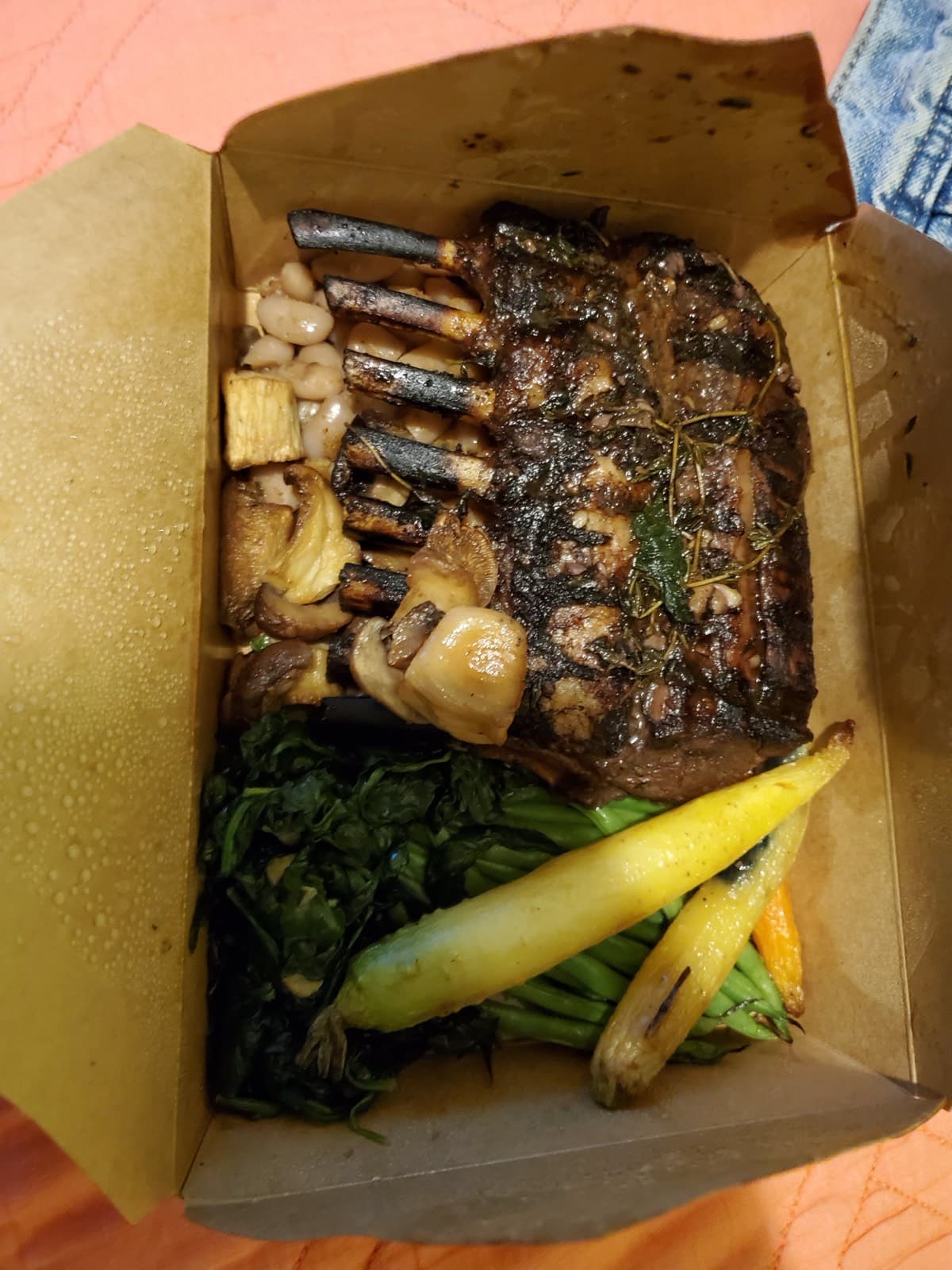Herb-crusted rack of lamb with sautéed greens and rainbow carrots for takeout